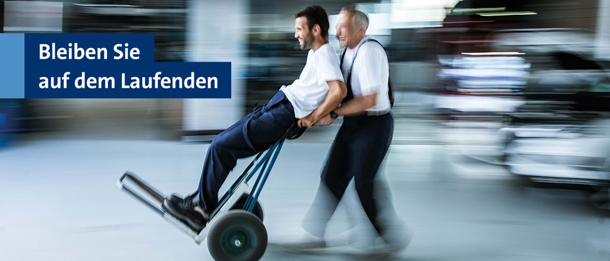 Bleiben Sie auf dem Laufenden mit dem Newsletter der Handwerkskammer Berlin. Zwei Handwerker, die auf einer Sackkarre durch eine Werkstatt fahren. Bleiben Sie auf dem Laufenden mit dem Newsletter der Handwerkskammer Berlin.
