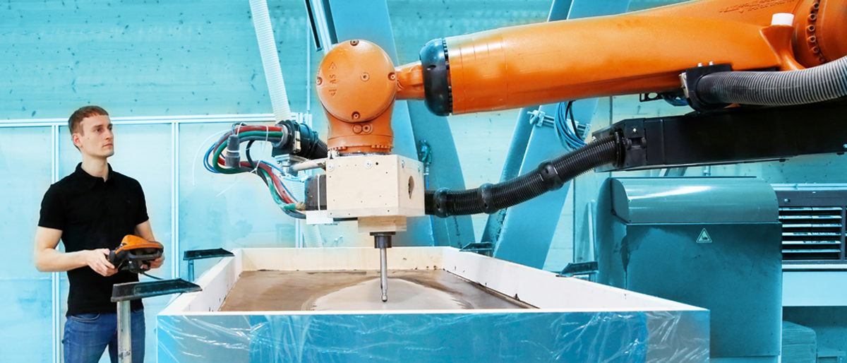 Handwerker arbeitet mit einem Gerät mit einem Roboterarm. 