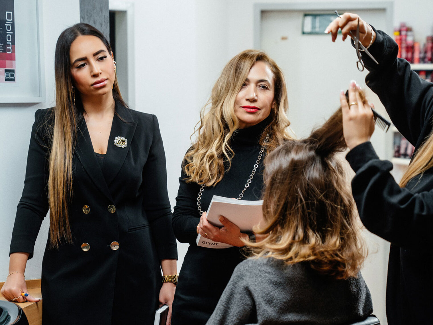 Nurten Tosun (l.) und ihre Tochter Nagihan Tosun (r.) sind darauf bedacht, dass die Friseur-Meisterprüfungen professionell ablaufen und eine gute Qualität haben. Das Bild zeigt sie während einer Prüfungssituation in ihrem Friseurstudio. 