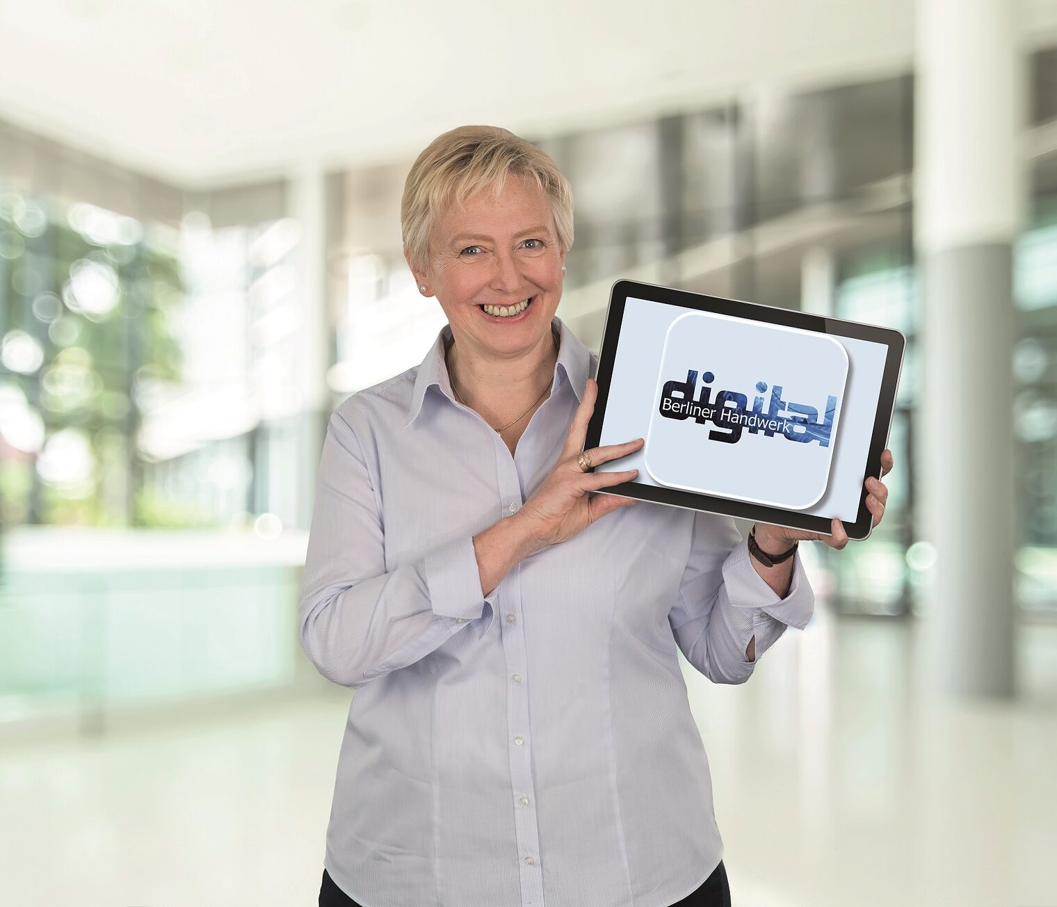 Kerstin Wiktor - die Beauftragte für Innovation und Technologie (BIT) bei der Handwerkskammer Berlin - mit einem Bildschirm in den Händen, mit Aufschrift "Digital"