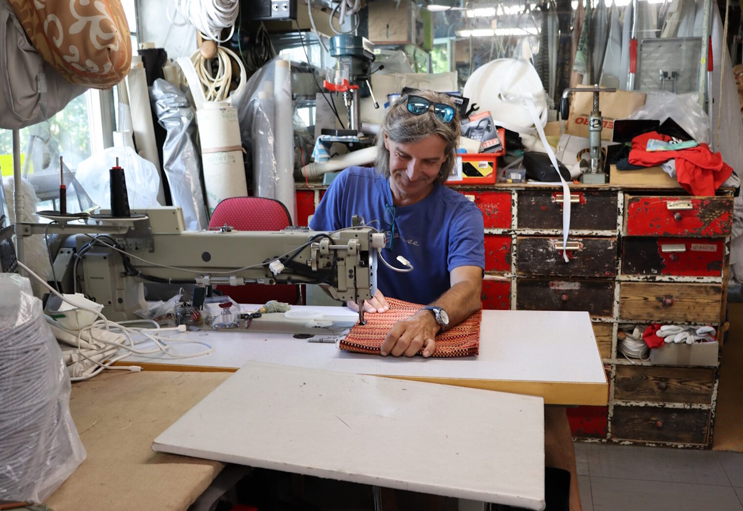 Raumausstatter Strehlow mit einem Projekt an der Nähmaschine in seiner Werkstatt.