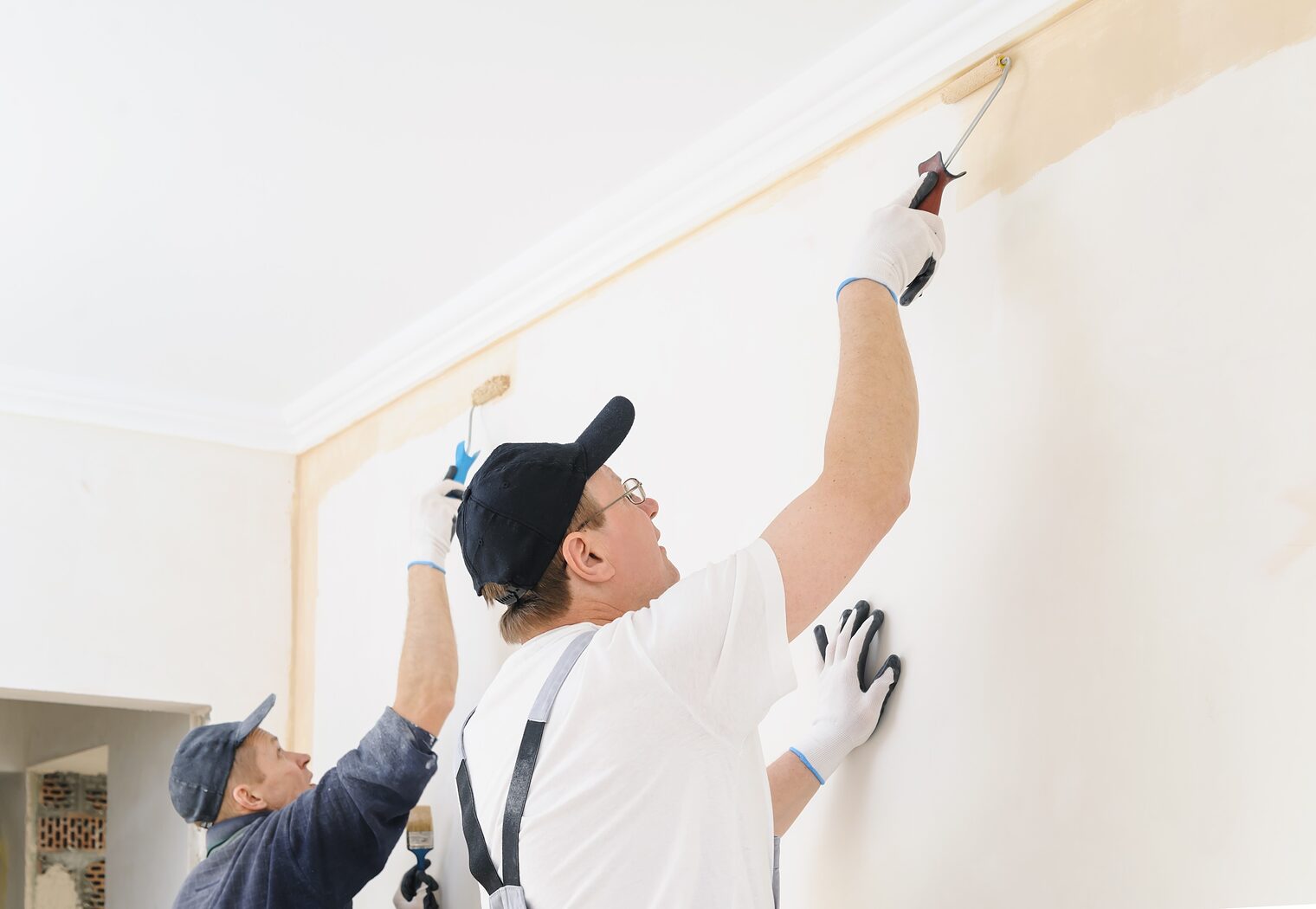 Handwerker streichen eine Wand