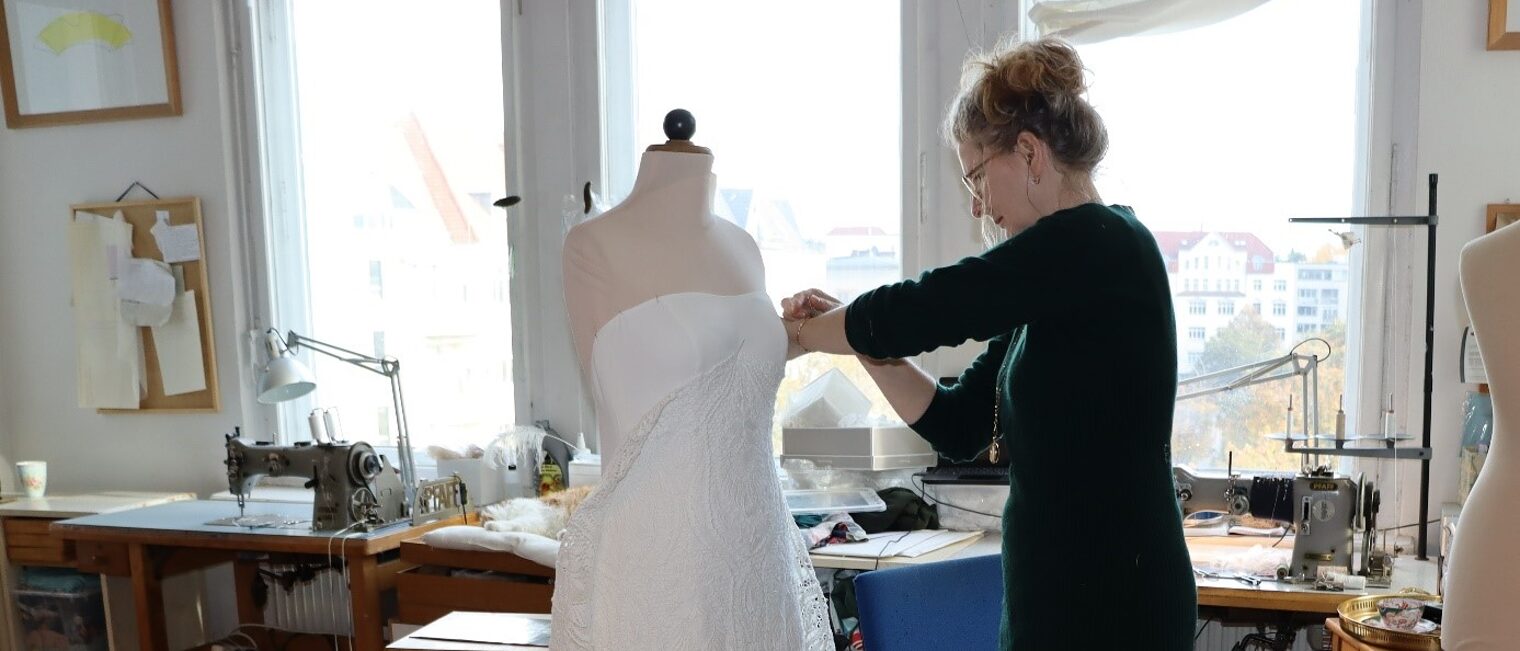 Ladengesch&auml;ft mit Brautkleider im Atelier Fiebelkorn. Frau Fiebelkorn arbeitet an einem Kleid. 