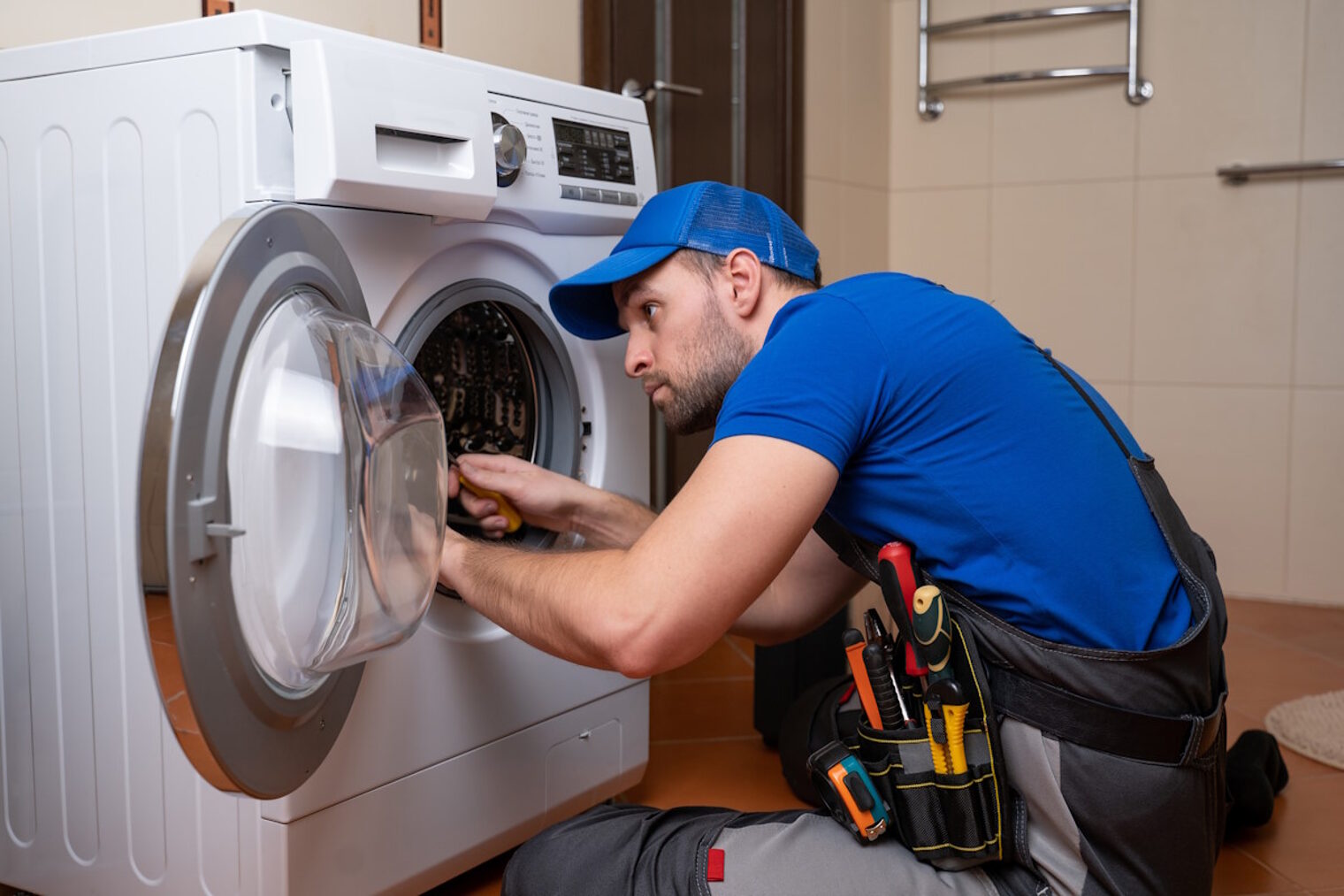 Mann repariert eine Waschmaschine