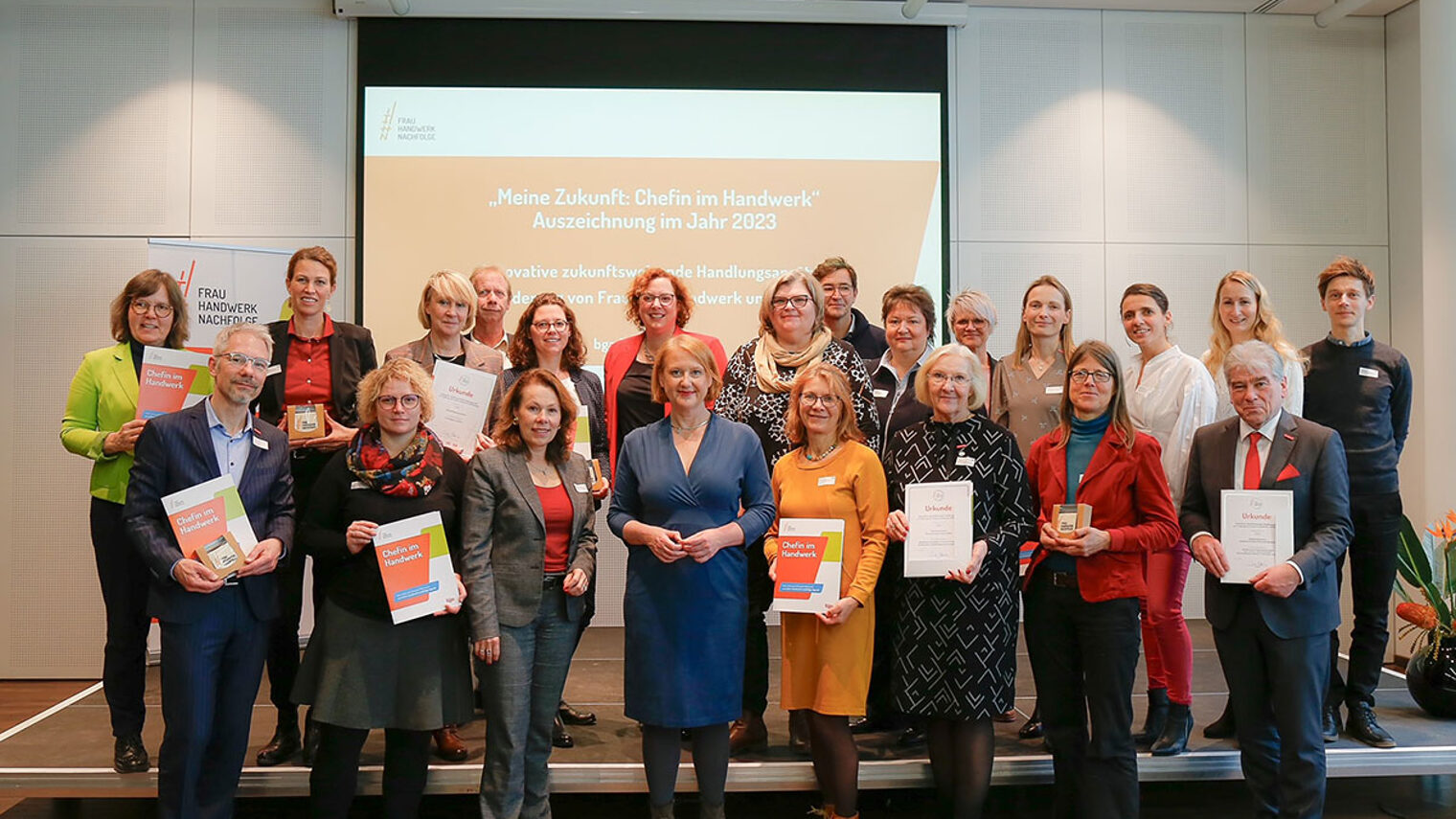 Gruppenfoto: Bundesminsterin Lisa Paus mit den Vertreterinnen und Vertretern der ausgezeichneten Handwerkskammern, die ihr Urkunden präsentieren.