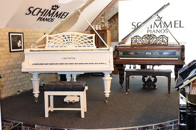 Zwei Klavier stehen auf einem Podest im Klaviersalon Berlin. 