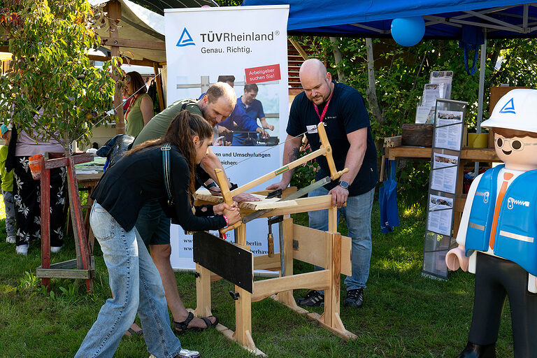Ein Mädchen beim Sägen am Aktionstag zur Berufsorientierung: Tag des Handwerks am 20. September 2025 im Mellowpark Berlin