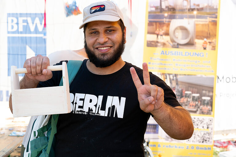 Ein junger Mann mit selbst geschnitztem Holzkasten für Werkzeug am Tag des Handwerks am 20. September 2025 im Mellowpark Berlin