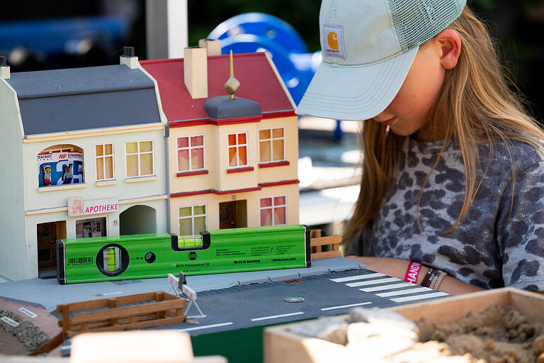 Ein Mädchen vor einem Miniaturhaus an einem Handwerkerstand am Tag des Handwerks am 20. September 2025 im Mellowpark Berlin