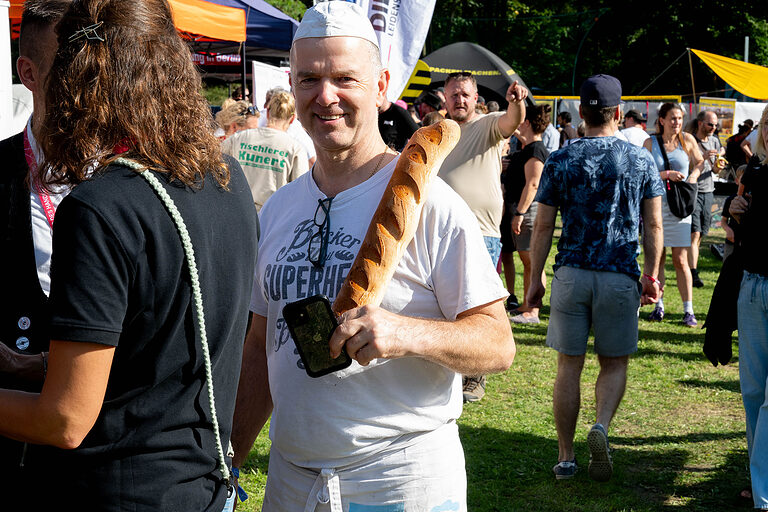 Ein Bäcker mit einem Baguette am Tag des Handwerks am 20. September 2025 im Mellowpark Berlin