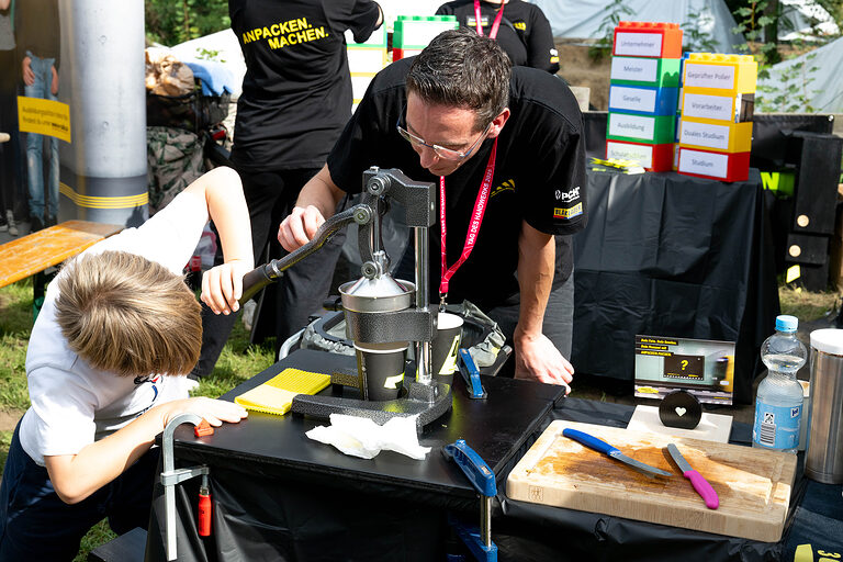Ein Junge beim Stanzen an einem Stand beim Tag des Handwerks am 20. September 2025 im Mellowpark Berlin