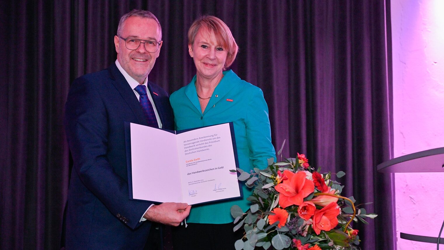 J. Dittrich, Präsident des Zentralverbands des Deutschen Handwerks (ZDH), übergibt der Präsidentin der Handwerkskammer Berlin, C. Zarth, das Handwerkszeichen in Gold.