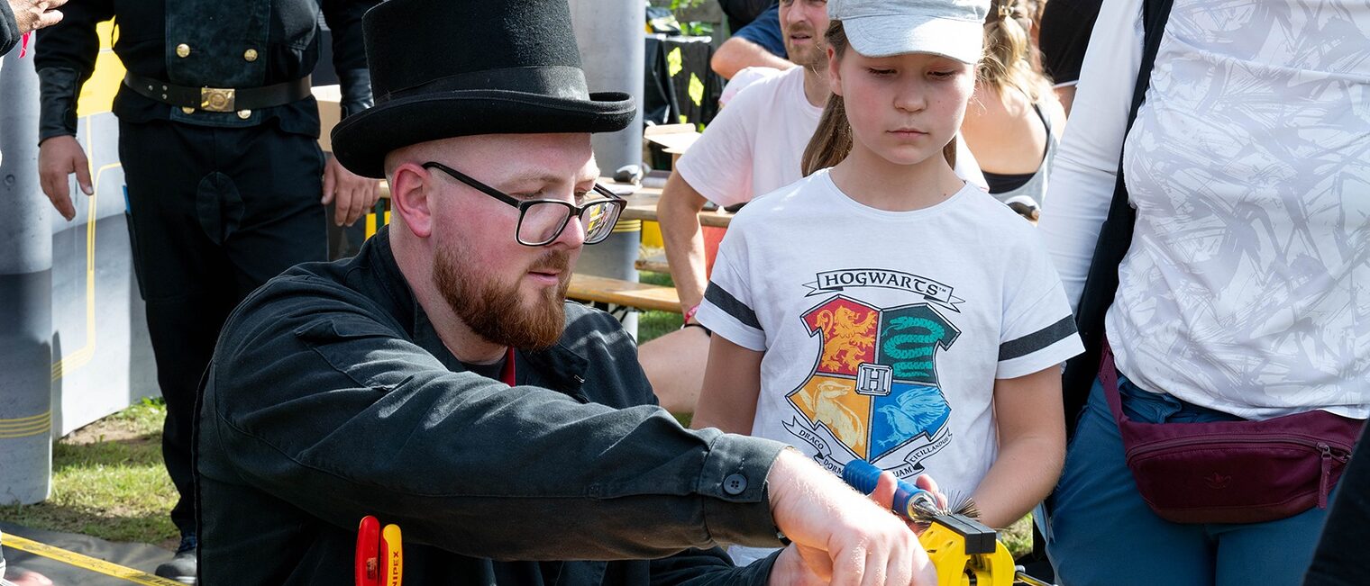 Tag des Handwerks im Mellowpark 2025. Ein Mädchen schaut einem Schornsteinfeger zu.