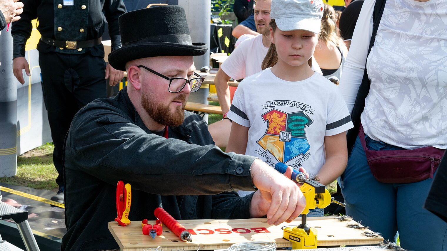 Tag des Handwerks im Mellowpark 2025. Ein Mädchen schaut einem Schornsteinfeger zu.