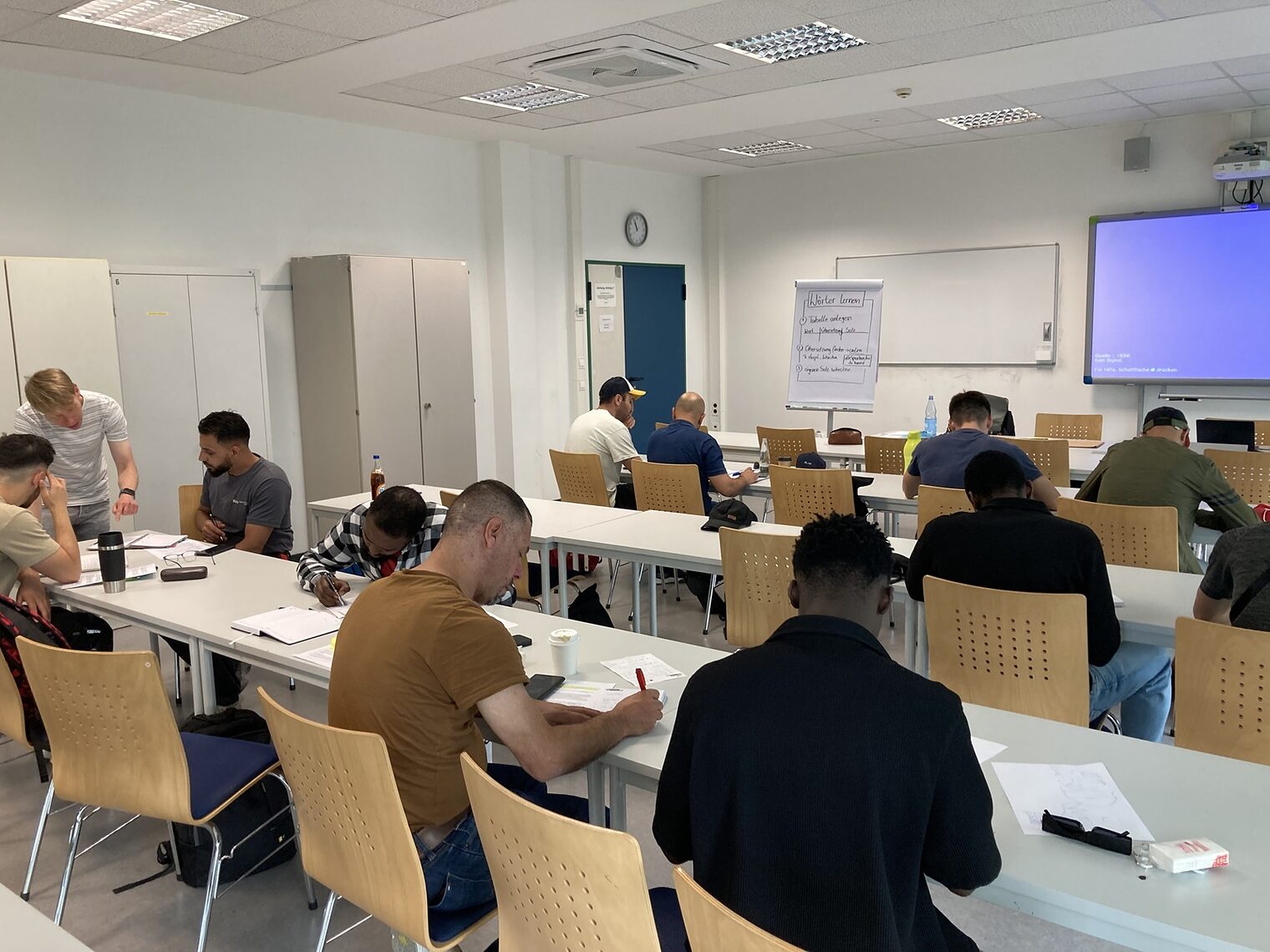 Azubi Akademie Deutschkurs Kursteilnehmende an den Tischen von hinten aufgenommen