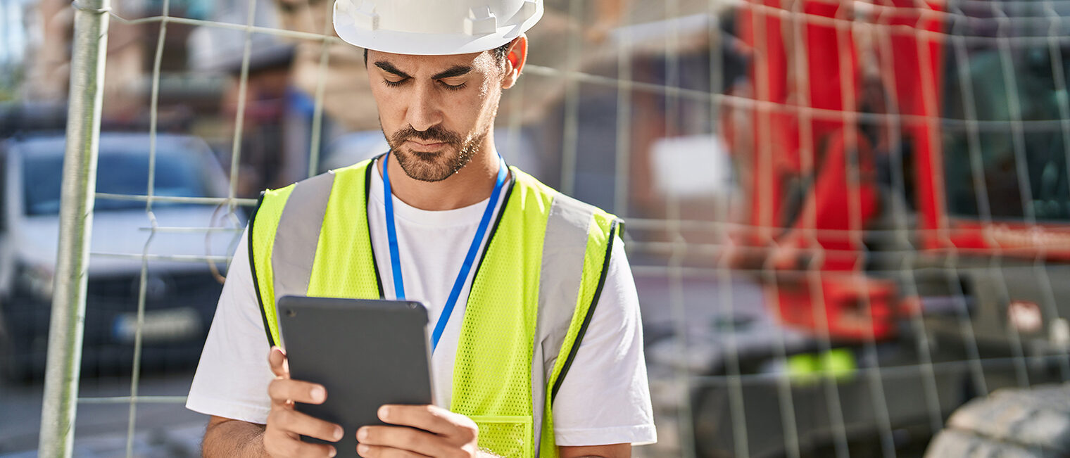 Bauarbeiter mit einem iPad auf einer Baustelle