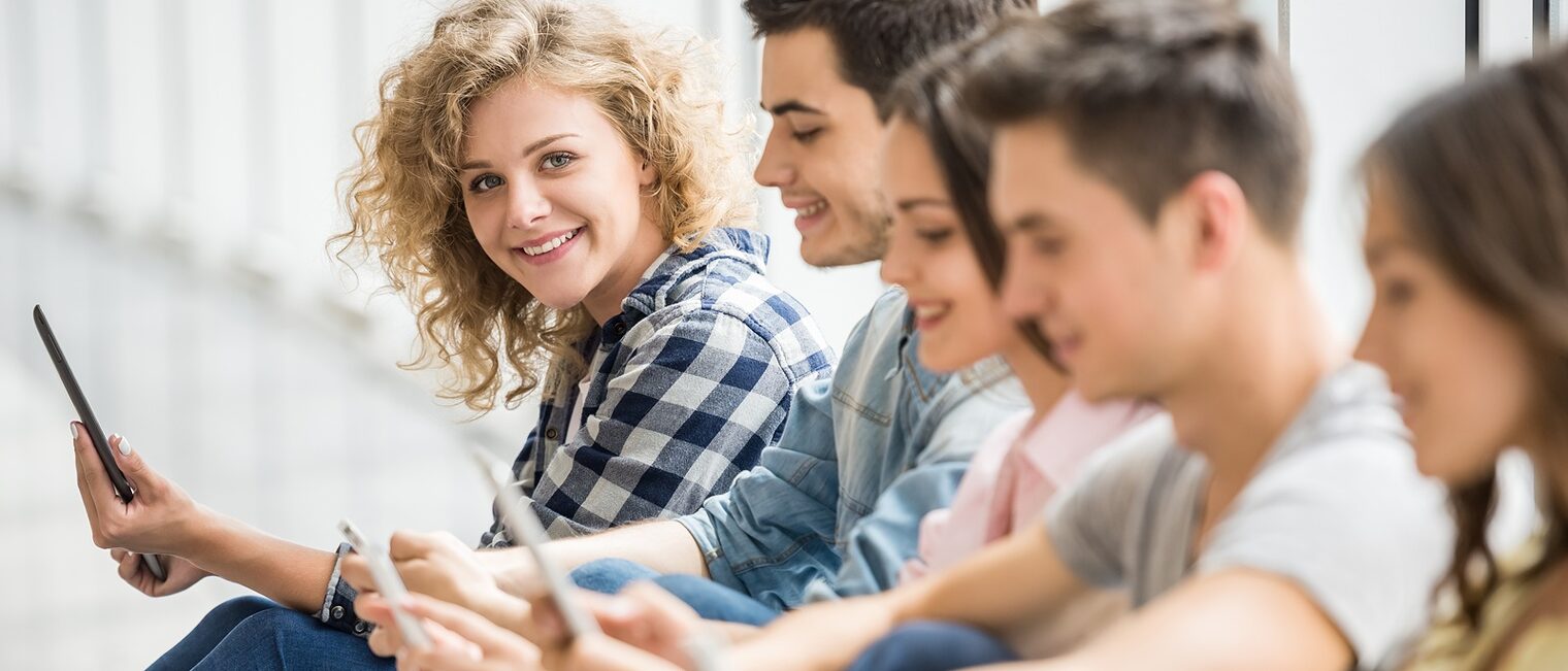 Studenten mit Gadgets sitzen zusammen