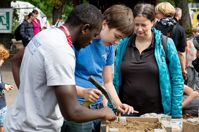 Junge mit Hammer und seiner Mutter an einem Aktionstisch am Tag des Handwerks im Berliner Mellowpark am 19.09.2026