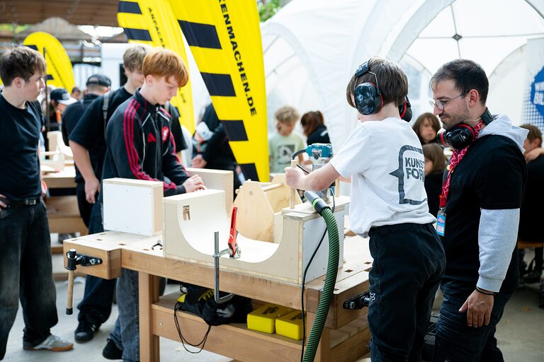 Ein Junge fertigt eine Fingerboard-Rampe am Tag des Handwerks 2026 im Melowwpark Berlin an. 