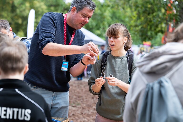 Eine Besucherin lässt sich etwas von einem Standbetreuer am Tag der Handwerks 2026 im Mellowpark Berlin erklären.