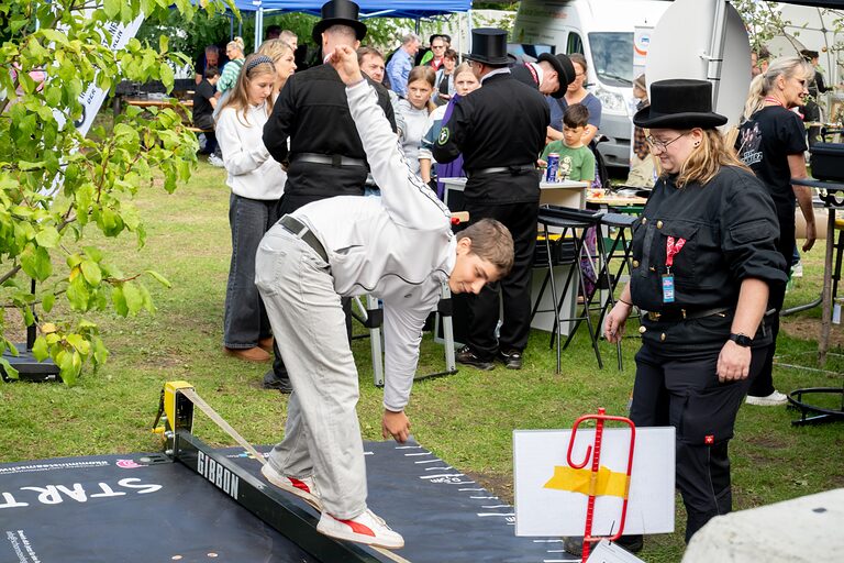 Ein Junge balanciert auf einem Seil am Stand der Schornsteinfeger am Tag der Handwerks 2026 im Mellowpark Berlin.