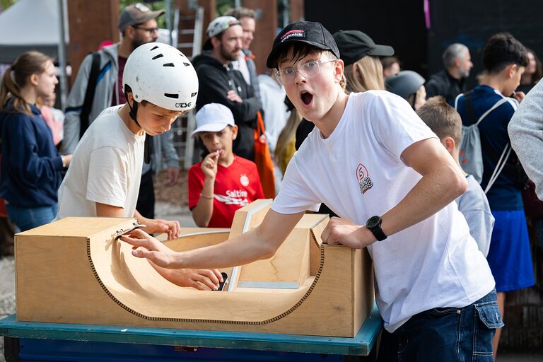 Ein Junge posiert an einer Holzrampe mit seinem Fingerboard am Tag der Handwerks 2026 im Mellowpark Berlin.